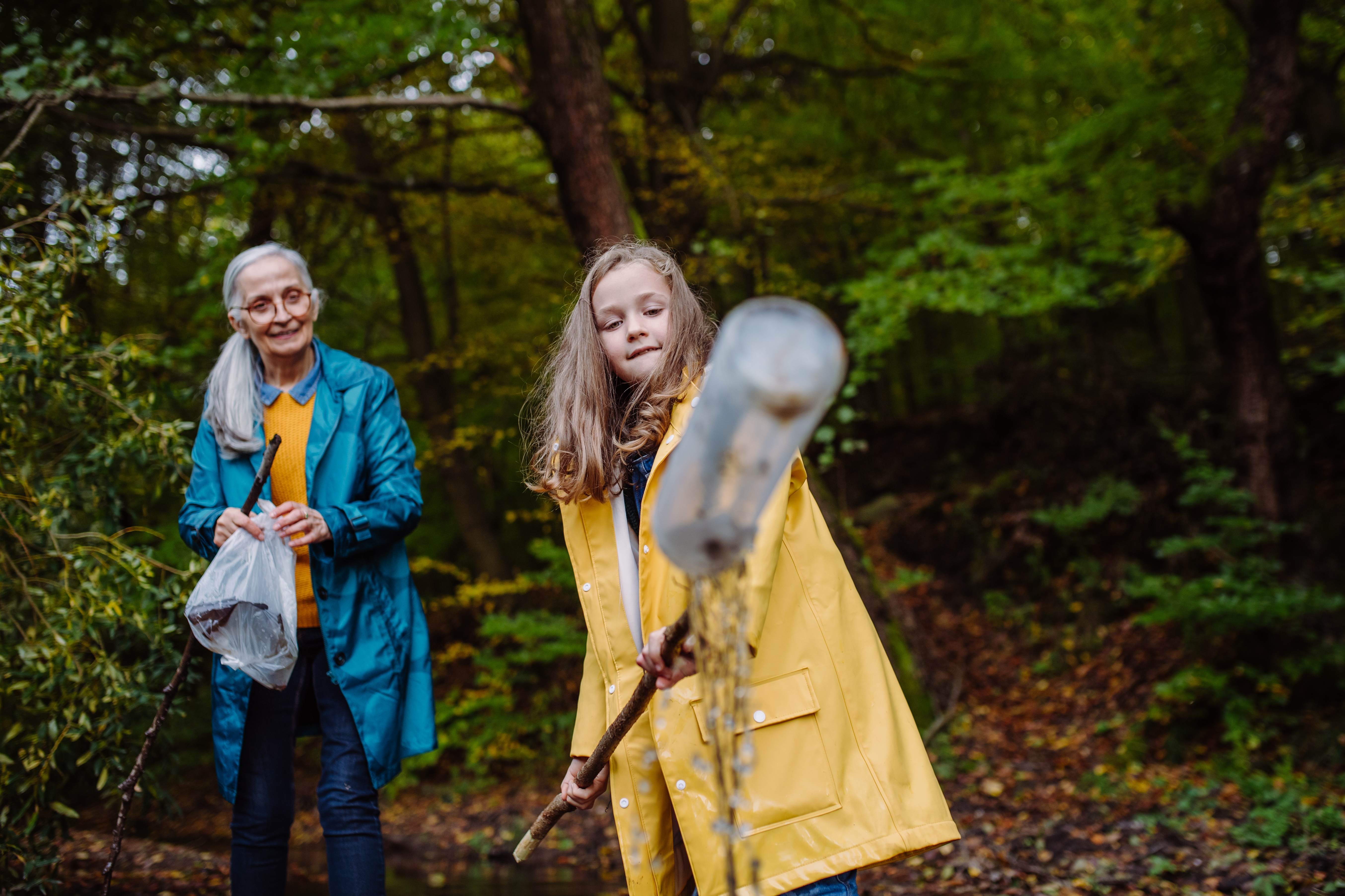 Grandmother and young girl exploring woodland together